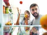 couple looking inside refrigerator