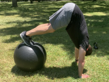 trainer doing pike on stability ball