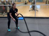 trainer doing workout with battle ropes