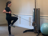 personal trainer doing single leg cable deadlift row
